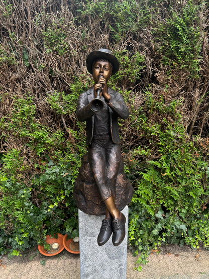 Estátua de bronze de menino com flauta.