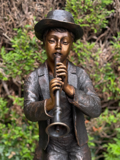 Estátua de bronze de menino com flauta.