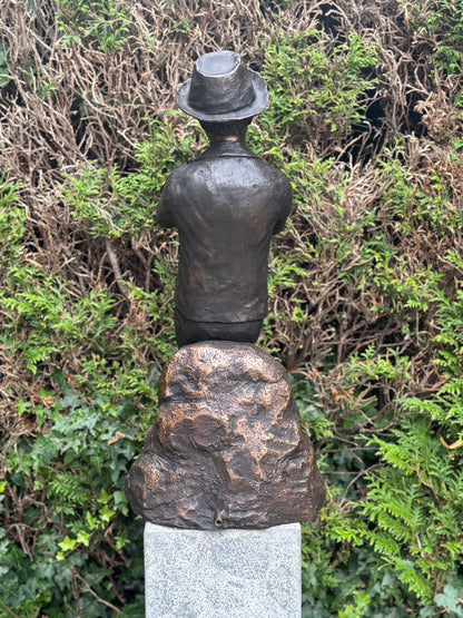 Estátua de bronze de menino com flauta.