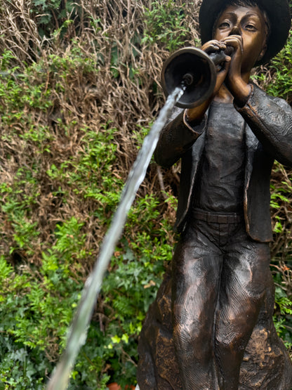 Estátua de bronze de menino com flauta.